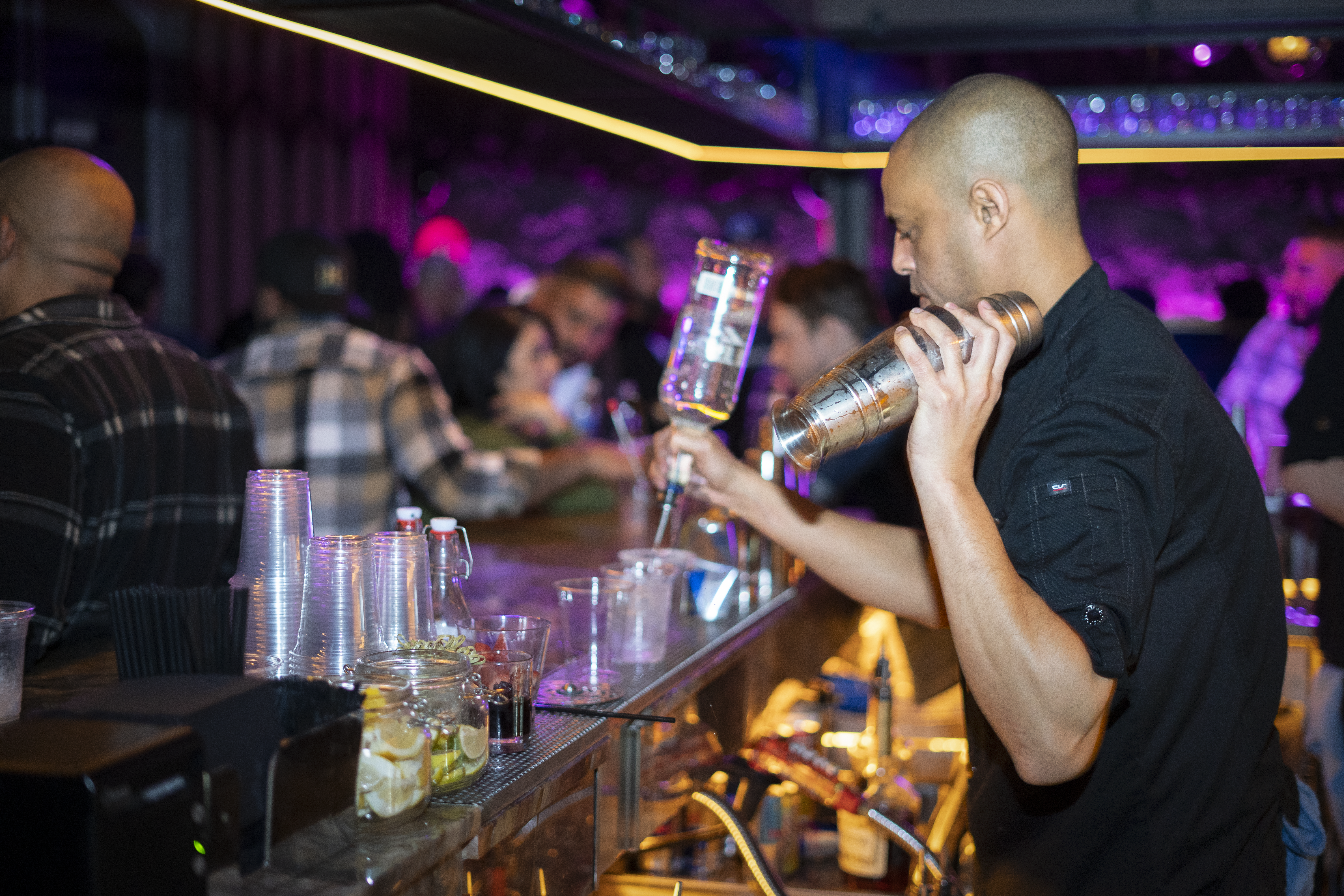 Nightclub scene with bartender pouring drinks